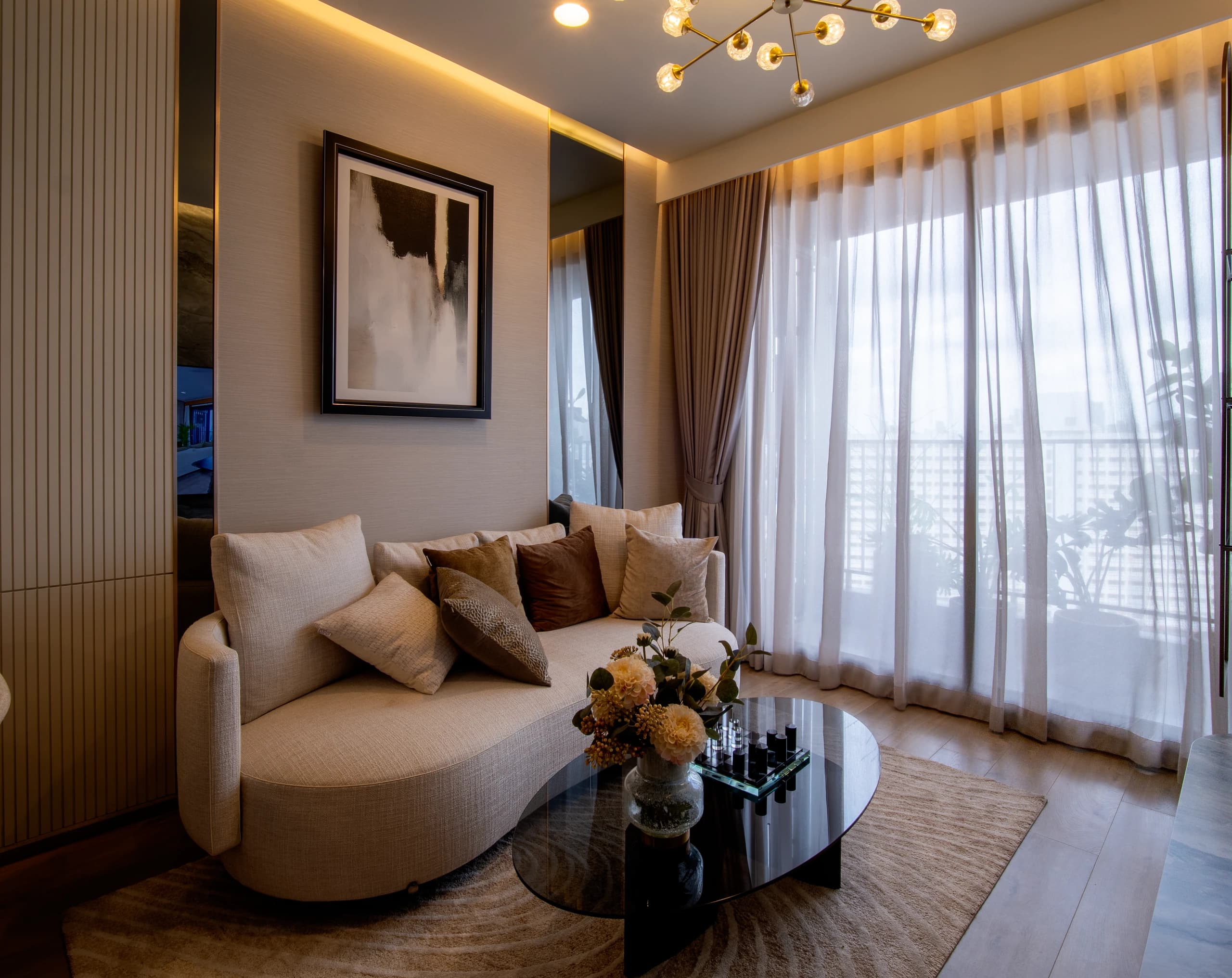 Room 1 (The Crown) — Living area with curved sofa, round table, and full-height curtains